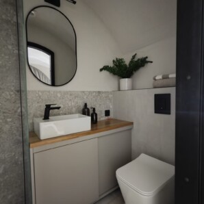 Revonia underground eco-house bathroom interior – modern concrete-look walls and vessel sink in earth home