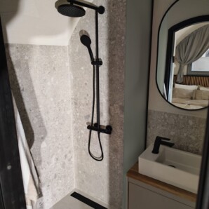 Revonia underground eco-house shower room – stone-look tiling and black fixtures in earth-sheltered home bathroom
