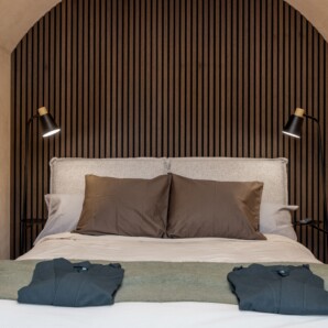Revonia underground house luxury bedroom – double bed with wooden slat feature wall under arched vault ceiling in modular earth home